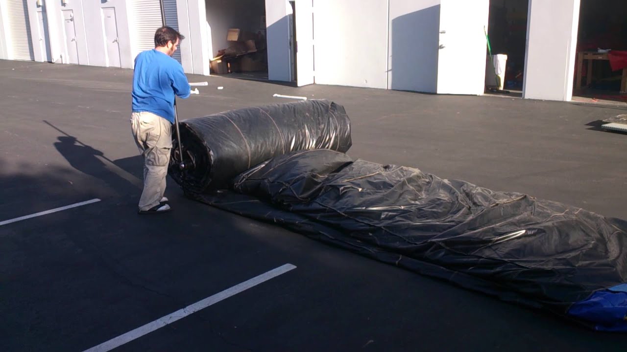One wimpy man rolling 850lb inflatable using inflatable rolling machine