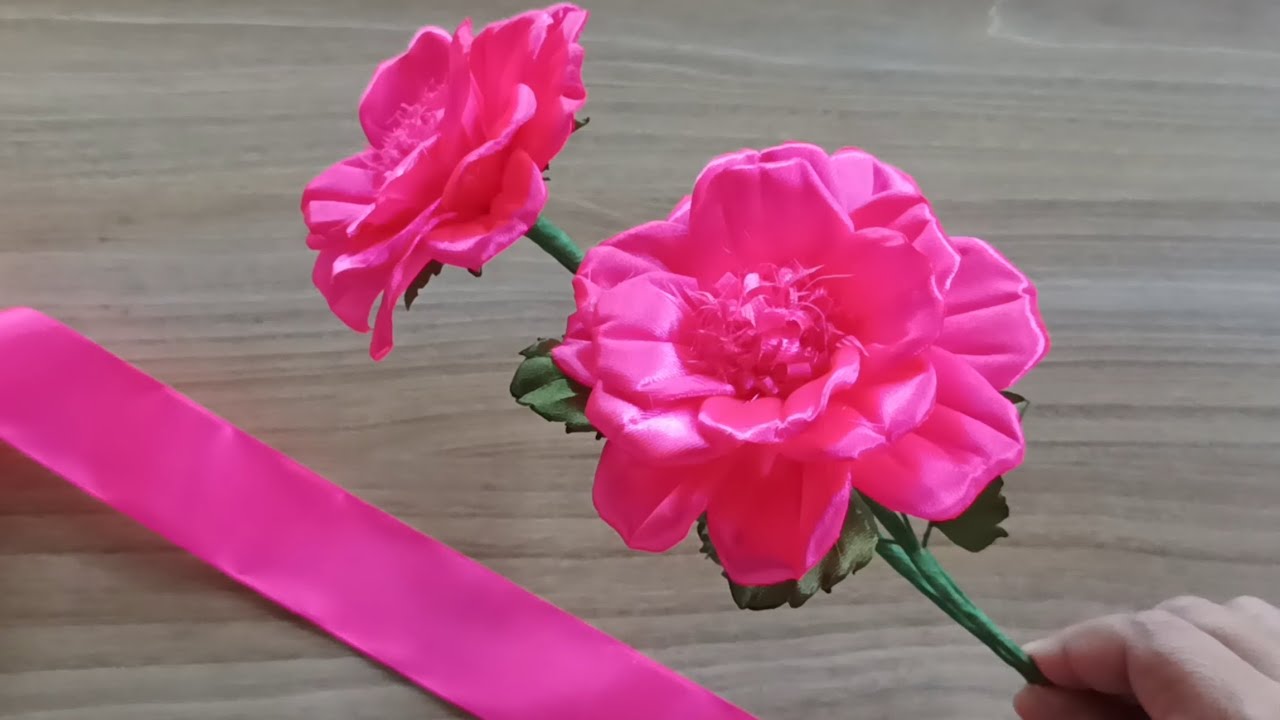 This bright pink satin ribbon flower is a handmade craft made using satin ribbon and floral wire.