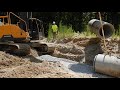 Excavator Setting Concrete Pipe And Box