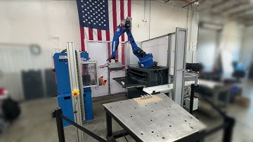 Machine-tending robot servicing a CNC and press from blank staging drawers to outbound conveyor