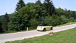 Mini Cooper With Laser Jama Exhaust Driving On A Curvy Road