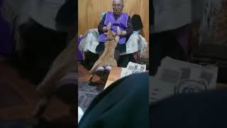 Lady Holding Cat Hands and Lifting It up and Down as It Lays on Her Legs
