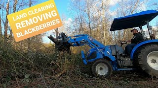 Land clearing with a root rake grapple