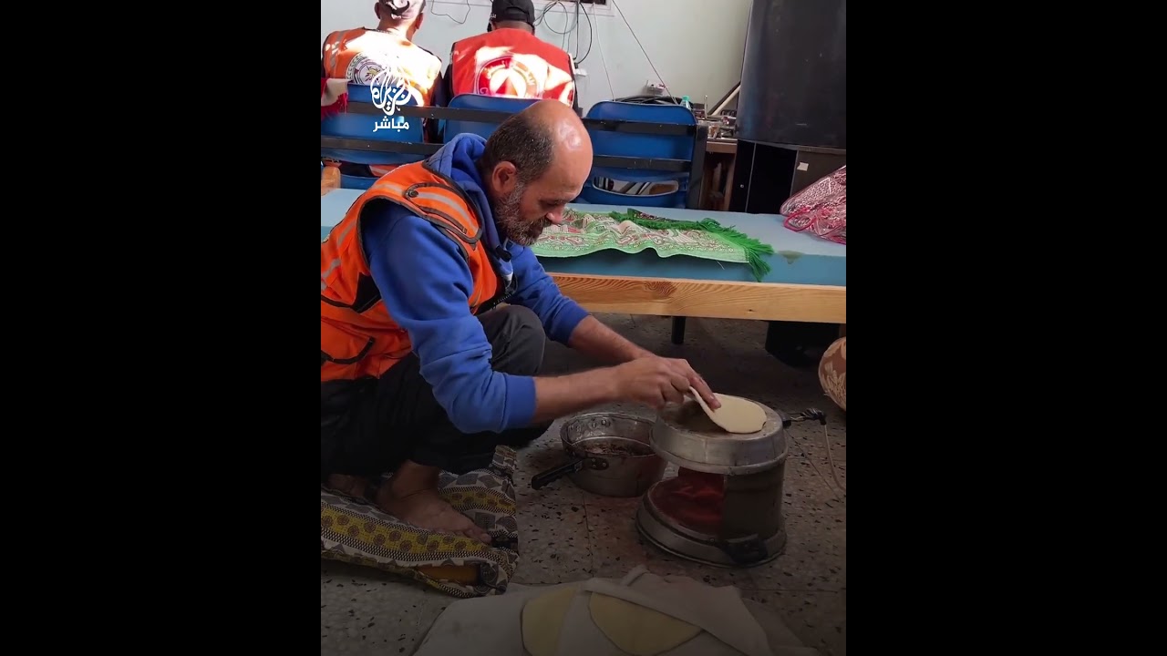 رجال الدفاع المدني الفلسطيني يصنعون الخبز لإطعام طفل نازح