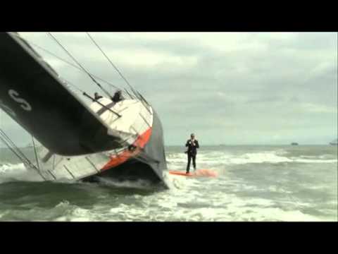 Alex Thomson debout, en mer, sur la quille de son bateau - YouTube