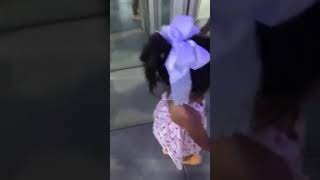 Little girl walks around glass maze room and bumps her face on the walls multiple times