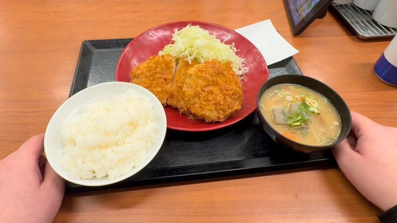 A Japanese salaryman eats a pork cutlet and minced meat cutlet set meal before his night shift.