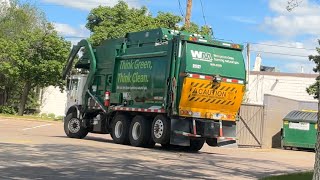 Waste management front-end loader pushing a dumpster back