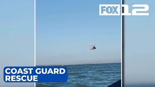Two people, dog rescued from capsized boat