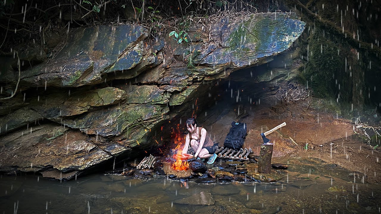 Build a survival shelter despite heavy rain - Bushcraft in the cliff ...