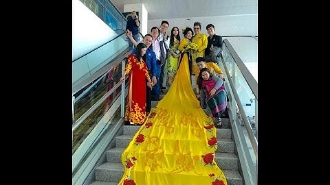 Mc Thanh Bạch cùng vợ đại gia làm lố với tà áo dài 5 mét quét đất ở sân bay