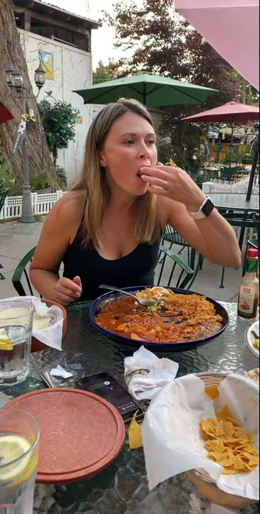 Girl tries to eat an oyster, but gags and spits it back into her plate.