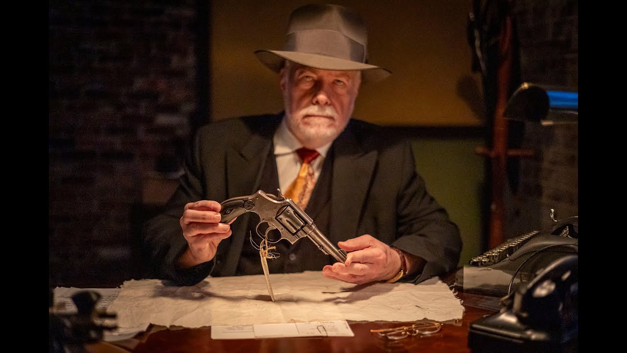 ASMR detective in his office late on a rainy night examining evidence collected from a crime scene.