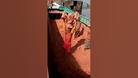 Человек  несёт на голове куча кирпичей