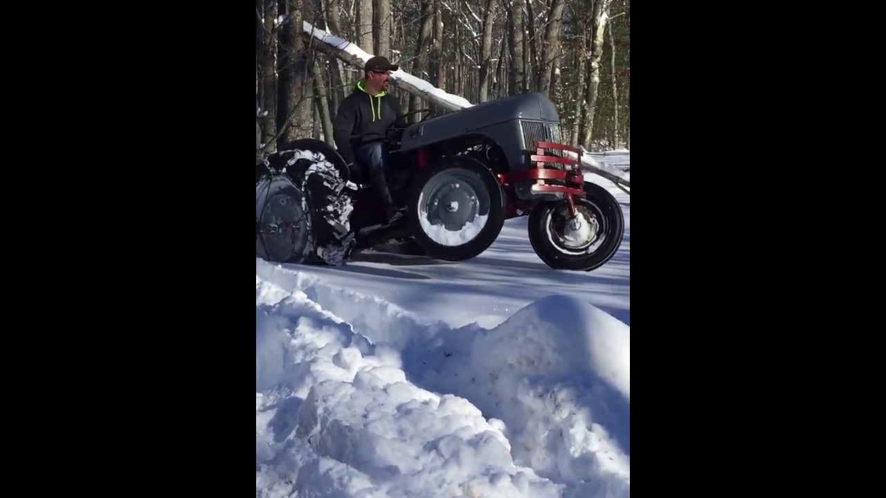 Ford 9N 8N tractor pulling logs through deep snow pulling a wheelie!