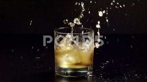 Whiskey Glass Ice Dropped In Slow Motion Stock Footage