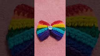 ​"Apne baalon ko dijiye ek colorful twist! Yeh handmade crochet rainbow bow aapke har outfit ko khas