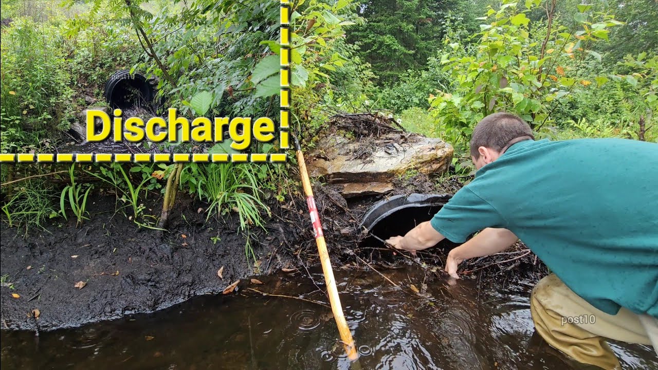 Прочистка водопропускной трубы под дождём на лесовозной дороге