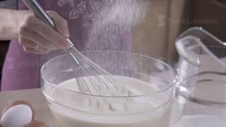 Female hands whipped the flour and eggs in mixing bowl