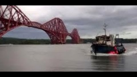 Boat Returning To Pier Below Forth Bridge On History Visit To North Queensferry Fife Scotland