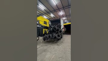 The tires in the truck bed are tied with ropes to facilitate unloading