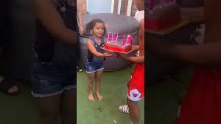 Girl walks out of house through sliding door holding birthday cake then her hair catches fire
