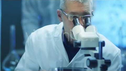 Scientist is Looking through Microscope | Stock Footage - Videohive