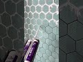 Applying Protective Adhesive Sealant To Hexagonal Wall Tiles For A Neat Modern Kitchen
