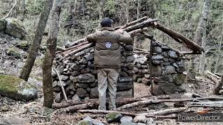 Building a stone shelter for survival in forest. solo bushcraft camping