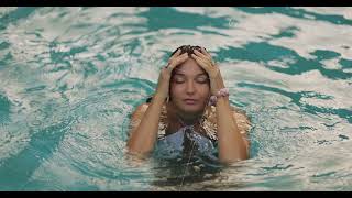 Woman In White Bikini Running Fingers Through Hair In Tropical Pool