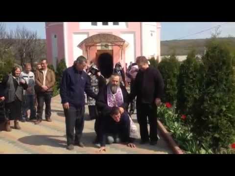 მღვდელი ზის კაცზე და აიძულებს იაროს