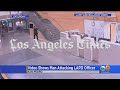 LAPD cop narrowly escapes death after attacker wrestles away his gun in police station and repeatedly pulls the trigger at pointblank range but leaves safety on