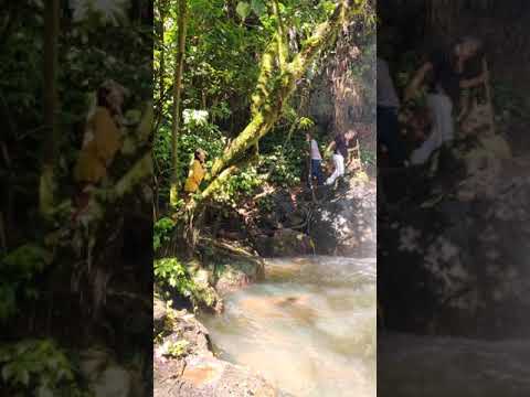 walking behind the amabere waterfalls in Fort Portal, Uganda