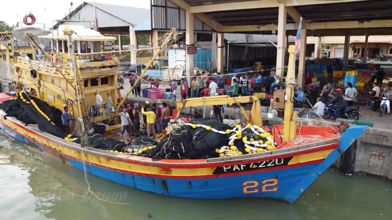 pelabuhan Chendering di musim tengkujuh dengan aktiviti nelayan memunggah hasil tangkapan