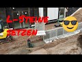 Bagger fahren - Doosan Bagger beim Traversen(Winkelstützen,L-Elemente,L Steine)auf Beton setzen,