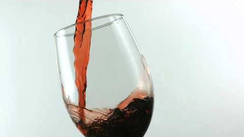 slow motion pouring glass of red wine