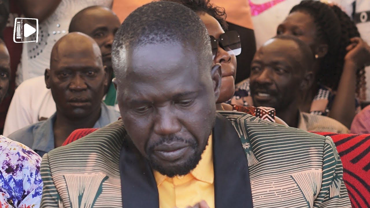 Босмик Отим (Святой Дух) провозглашает «политическую троицу Аколи» — д-р Одонга (отец), д-р Олань...