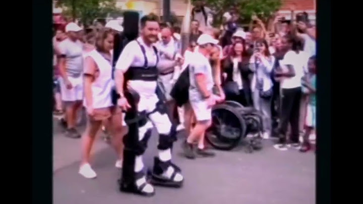 Paraplegic athlete, in exoskeleton, carries Olympic flame. 