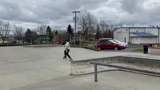 Inline skater jumps box at skatepark then falls and bumps head on ramp