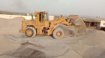 Old Cat 950 E-series wheel loader, filling the hopper on the truck loading plant, in a lime quarry