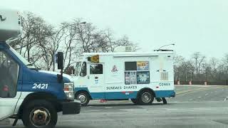 2 Mister Softee trucks passing by 