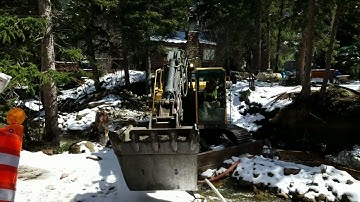 Pouring concrete bridge abutment footing with excavator bucket