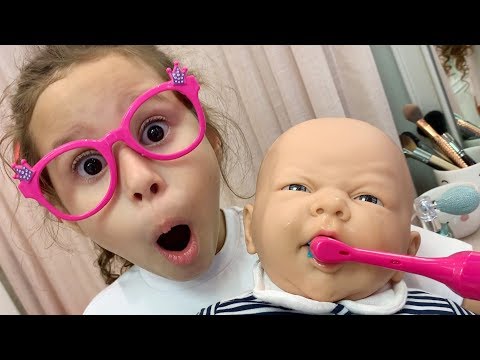 Valentina fingir brincar com bebê de brinquedo de escovar os dentes