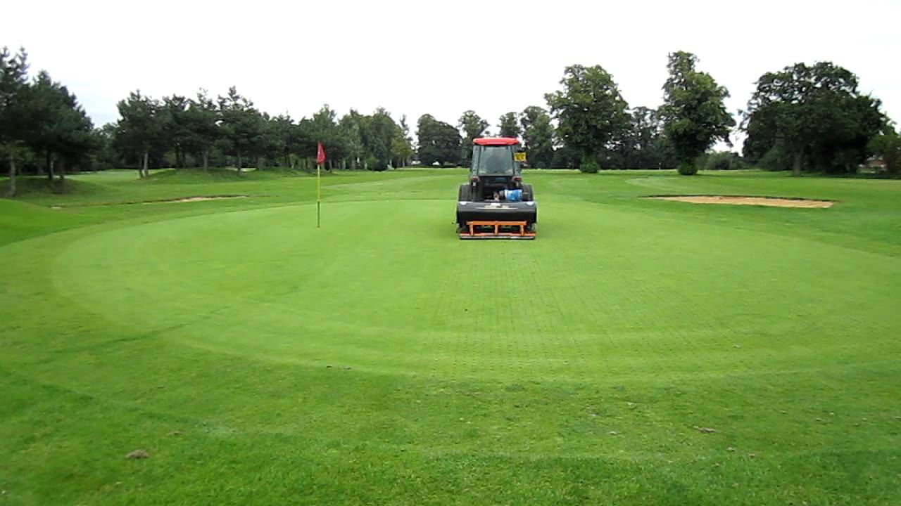 Golf Course Maintenance Aerating a golf green with a Sisis Aeraid