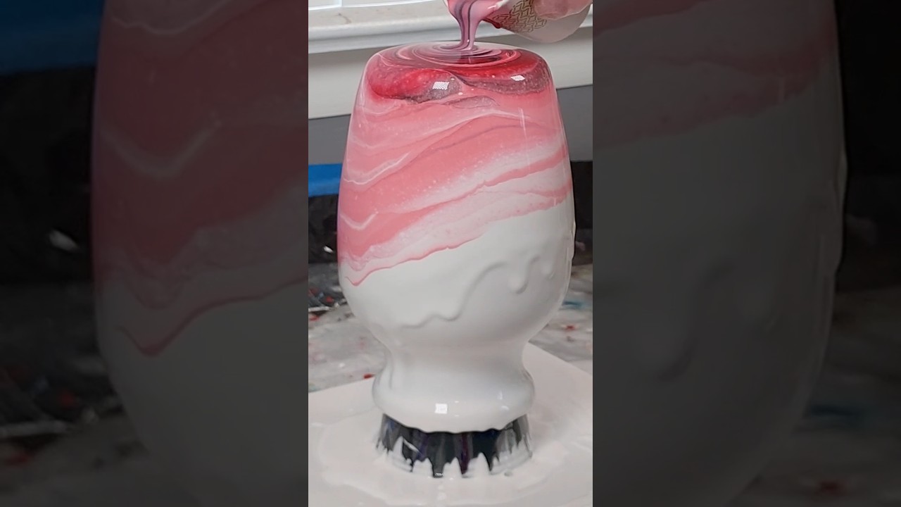 Pink paint pour on a vase, from the side