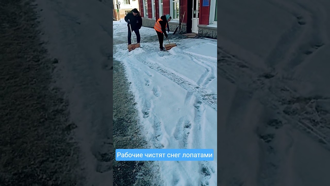 Рабочие чистят снег лопатами