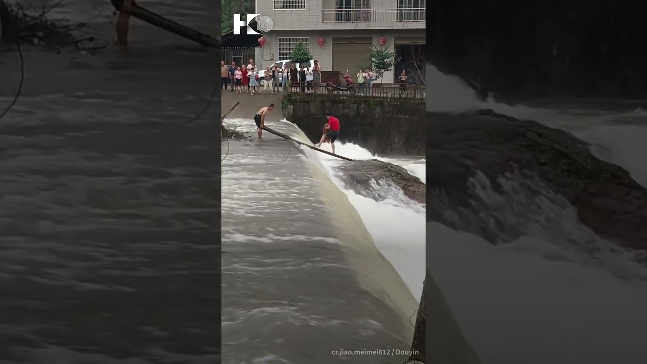 A dog trapped in swift floodwaters was rescued by two brave villagers in Southern China.