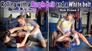 A Brown belt rolling with a Purple belt and a White belt