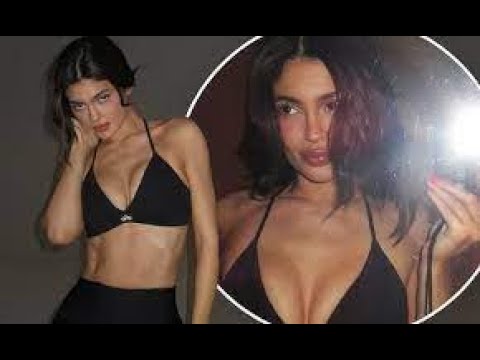 Kylie Jenner shows off her washboard abs in a plunging black sports bra and biker shorts