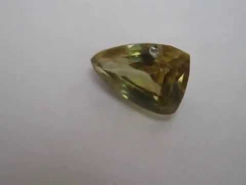 Batu permata Zircon alami warna kuning dengan luser emas kecoklatan yang cukup indah, bentuk kotak c. 